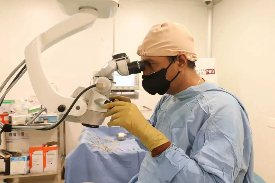 Dr. Rajesh Shah operating at a surgical microscope
