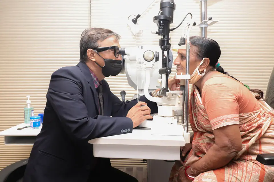 A doctor examining a patient at the slit lamp